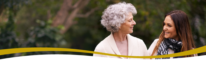 Senior woman and adult child caregiver talking about assisted living communities Senior woman and adult child caregiver talking about assisted living communities